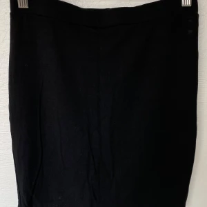 Svart kortkjol från SHEINSXY - En stilren svart kortkjol från SHEINSXY i enkel design. Kjolen har rak passform och är gjord i mjukt syntetmaterial som känns skönt mot huden. Perfekt att matcha med en cool topp eller hoodie för en chill look.