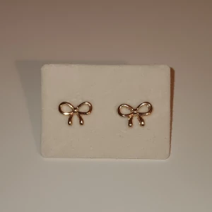 Guldiga rosett öronhänge  - Guldiga rosett öronhängen som har ALDRIG! Används💕