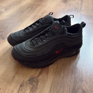 Nike Air Max 97  - Nike Air Max 97 sneakers i helsvart med röda detaljer. Använda 2-3 gånger nypris 2249