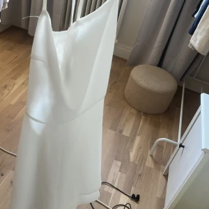 Vit omlottklänning från SHEIN XS - Supersöt vit klänning från SHEIN i omlottmodell med tunna axelband och flowy kjol. Klänningen har en stilren look och är perfekt för dig som gillar minimalistisk stil. Materialet känns lätt och svalt, och modellen ger en snygg siluett.