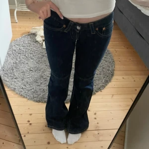 Lågmidjade jeans - Mörkblå Levi's 527 jeans med bootcut passform och låg midja. I bra skick förutom att de är lite trasiga vid hälarna. W28 L34, midjemått ät 37-38 och innerbenslängd är 90