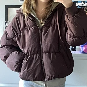 Brun pufferjacka med huva - Mest lik i färgen på första bilden. Använd några få gånger.