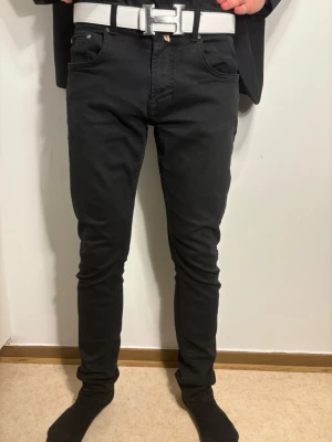 Svarta Morris jeans - Säljer ett par svarta Morris jeans med slim passform och klassisk femficksdesign. Jeansen har en snygg mörk ton och är tillverkade i mjukt jeansmaterial med stretch. Perfekt för dig som gillar stilrena och bekväma jeans.