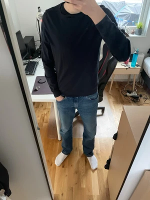 Mörkblå stickad tröja från Massimo Dutti - En stilren mörkblå stickad tröja från Selected Homme. Tröjan har rund halsringning, ribbade muddar vid ärmslut och nederkant samt lång ärm. Perfekt till jeans eller chinos för en clean look.