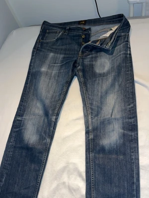 Lee jeans Darren - Tjena! Säljer dessa otroligt vackra jeans från Lee Jeans, storlek W29 L32. Måtten är 17cm i benöppningen, 40cm i längden och 101cm långa Modellen är ”Darren”, vilket liknar en slim/straight passform. Mycket fin tvätt på jeansen. Tveka inte i att höra av dig ifall om du har några frågor eller prisförslag!