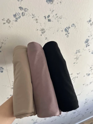 Tre par leggings i olika färger - Säljer tre par mjuka leggings i beige, lila och svart. Perfekta för dig som vill ha bekväma och stilrena byxor till vardagen. Materialet känns lent och stretchigt, vilket gör dem sköna att bära hela dagen.