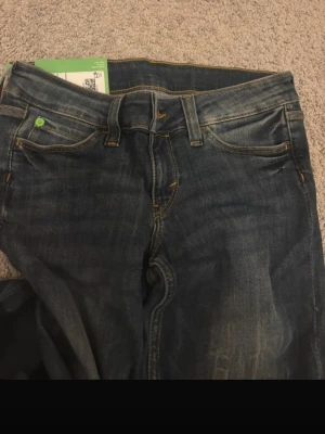 Blå Cheap Monday jeans Booty 28/34 - Säljer ett par klassiska blå jeans från Cheap Monday i modellen Booty. Jeansen har normal passform, fem fickor och snygga slitningar framtill. Materialet är slitstark denim med kontrastsömmar och de har en tidlös look som funkar till allt. HELT OANVÄNDA MED PRISLAPP PÅ