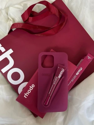 Rhode case  - Effortless minimalism with a quiet statement. The Rhode Case blends sleek design with everyday function, featuring a built-in slot for your lip treatment so essentials are always within reach. Soft lines, modern simplicity, and a refined aesthetic that elevates your phone and your look.  •	✨ Minimal, elegant design 	•	💄 Built-in holder for lip treatment 	•	📱 Lightweight protection without bulk 	•	🤍 Clean, modern, timeless aesthetic 	•	🔥 Perfect for an effortless, polis
