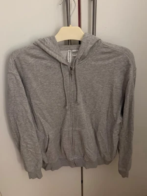 Grå hoodie - H&M - En grå hoodie från H&M, är perfekt till tillfällen då man vill chilla eller ska till gymmet. Är i ett fint skick, säljer pga ingen användning längre!💕