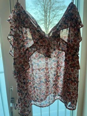 blommig blus i ett tunt material. - blusen är perfekt till sommaren, har skönt material och har ej använts ofta.