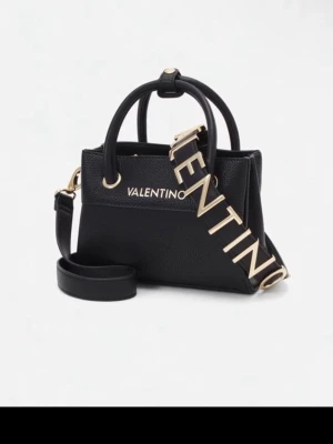 Svart handväska från Valentino - Snygg svart handväska från Valentino med guldfärgade detaljer och stort VALENTINO-strap. Väskan har både handtag och justerbar axelrem samt flera fack inuti, inklusive ett med dragkedja. Tillverkad i strukturerat skinnliknande material.