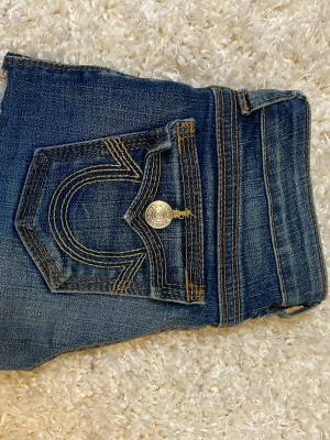 True Religion jeansshorts - uper snygga true religion jeans shorts klippta från jeans. De är i hyfsat bra skick men har en lagning, som inte syns när shortsen är på, se bild 4. Märket är även slitet, se bild 3. Säljer pga de tyvärr blivit för små, pris går såklart att diskutera❣️🥰