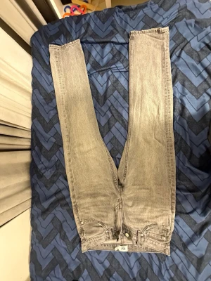 Grå jeans från 157, straight fit - Säljer ett par grå tvättade jeans från 157 med klassisk femficksmodell och raka ben. Jeansen har normal passform och dragkedja i gylfen. Perfekta till en avslappnad stil och funkar året runt.
