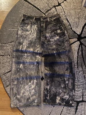 Acne Studios 1981M Loose Fit Byxor “Cold Grey” - Acne Studios loose fit-byxor i modellen 1981M i den eftertraktade färgen Cold Grey, med Acne’s signatur trompe-l’oeil print. || Storlek L/52  || Modell: 1981M (Loose Fit) || Färg: Cold Grey || Material: 100% bomull || Passform: Loose / Baggy  || Mått: 92cm midja, 111cm längd. ||