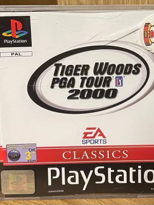 Tiger Woods PGA Tour 2000 (PlayStation Classics) - Klassiskt golfspel för PlayStation, Tiger Woods PGA Tour 2000. Komplett med originalfodral och manual. PAL-version, stöd för 1-4 spelare, analog och vibration. Fint skick, perfekt för samlare eller retrospelare.