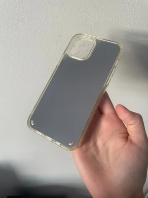 Spegel skal iPhone 12  - En spegel skal för iPhone 12. Ger bra skydd mot repor och stötar, med förstärkta hörn. Skalet är i mycket gott skick endast använd 1-2 ggr utan synligt slitage eller missfärgning.