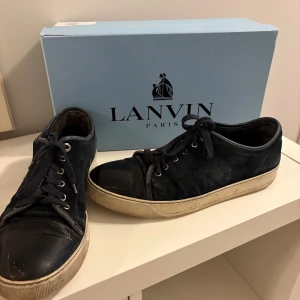 Lanvins, mörk blå - Har ett par feta Lanvins, de har blivit använda så lite sämre skick(5/10) vilket förklarar priset. De är mörk blå och passar till det mesta. OBS! Framsidorna på skorna är creasade och har små deffekter som knappast är synliga. Mockan är i helt ok skick. Pris går att diskuteras vid snabba affärer.