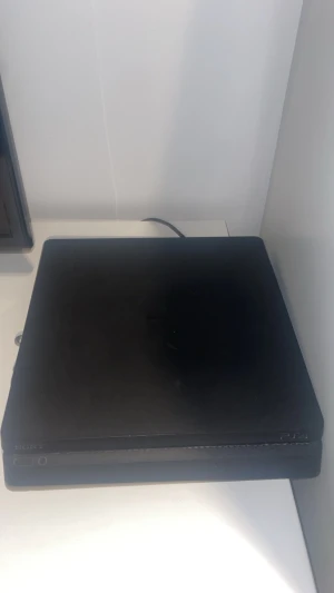 PlayStation 4 Slim - Sony PlayStation 4 Slim i svart. Konsolen är i gott skick med mindre tecken på normalt bruk, inga större repor eller skador synliga. Perfekt för gaming och underhållning. Strömkabel ingår, handkontroller och spel säljs separat.