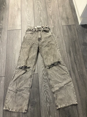 Fina bredda jeans med hål vid knän  - Fina bredda jeans med hål vid knän. Högmidjade 