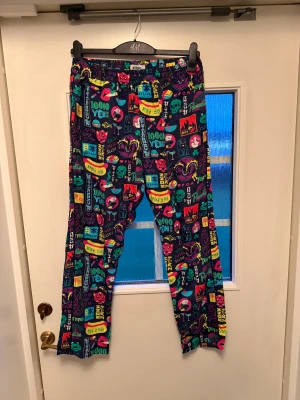 Nikben Byxor - Säljer ett par mjukisbyxor från Nike med  färgglatt och japanskt inspirerat mönster. Byxorna har elastisk midja och är gjorda i mjukt material, perfekta för chill dagar. 