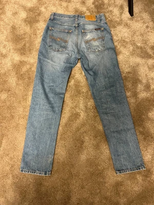 Nudie Jeans Steady Eddie II ljusblå - Säljer ett par Nudie Jeans Steady Eddie II i ljusblå färg. Klassisk modell med raka ben och snygga kontrastsömmar. Jeansen är tillverkade i 100% bomull och storleken är W28 L30. Pris går att diskutera. 