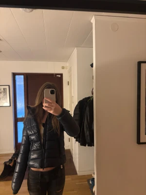 Svart pufferjacka med huva - Säljer min mörkblåa trendiga jacka ifrån lager 157. Den är varm,skön och snygg. Inte använd särskilt mycket. 