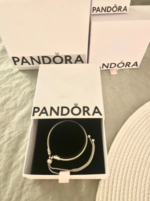 Pandora berlockarmband - Säljer ett justerbart ormkedje/ moments armband i sterling silver från pandora 💗                                                                                        Köpte för 800 kr fast säljer för 499.                                                 ‼️Berlockerna på sista bilden ingår INTE‼️                                                                                                                          Men säljer även en av berlockerna på en av mina andra annonser, så kika gärna där 🥰🥰