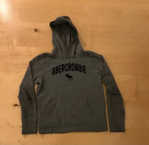 Abercrombie and Fitch hoodie  - Säljer denna denna gråa Abercrombie and Fitch hoodie i storlek 15/16 kids vilket jag skulle uppskatta är xs. Har du frågor, hör gärna av dig🙌