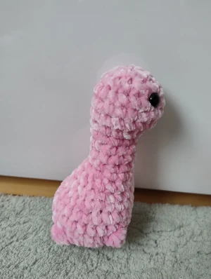 Handgjord virkad dinosaurie  - Handgjord virkad rosa dinosaurie som jag har gjort. Virkad med fluffigt garn och fylld med mjuk vadd. Har även ögon som sitter fast säkert från insidan och gör den extra söt.