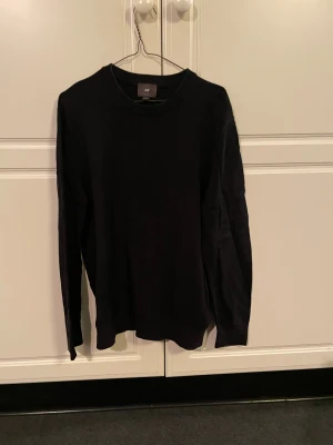 Svart H&M sweatshirt - Säljer denna svarta långärmade stickade sweatshirt från H&M. Den är i storlek L, slim fit. Vet inte om modellen fortfarande säljs men liknande modeller ligger runt 250kr. Tröjan är i rätt bra skick utan några visuella defekter. Hör av er vid eventuella funderingar!