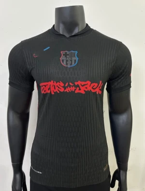 Svart FC Barcelona fotbollströja Nike - Snygg svart FC Barcelona fotbollströja från Nike med klubbmärke på bröstet och röd graffiti-inspirerad text över magen. Tröjan har korta ärmar, rund hals och diskret mönster i tyget. Perfekt för dig som vill sticka ut på planen eller läktaren.