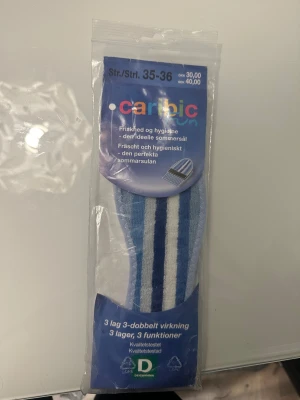 Randiga Caribic Fun sommarsulor 35-36 - Caribic Fun sommarsula för fräschhet och hygien. Den perfekta sommarsulan som passar alla skor. Kan användas i skor eller strumpor. Säljer ett par blå och vita randiga sommarsulor från Caribic Fun, perfekta för att hålla fötterna fräscha i alla typer av skor. Sulorna har tre lager: bomullsfrotté, latex med aktivt kol och mjuk latex med halkskydd. Sköna och hygieniska, passar även barfota.