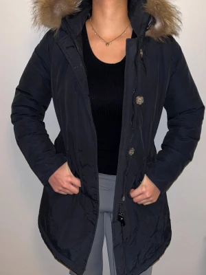 Varm vinterjacka M dam- fräsch och varm! - Denna jacka har en fin längd och en normal passform, perfekt för de kallare månaderna. kroppsfodret är 100% polyester. Jackan har två yttre fickor och har ingen innerficka. Kollektionen är speciellt designad för vintern och levereras med en standardstor pälskrage. Observera att pälskragen är tillverkade av naturliga material, så varje päls kan ha en unikt utseende.   Jackan är knappt använd!  Skicket är väldigt bra!  Storlek: M   Skriv så kan pris diskuteras!