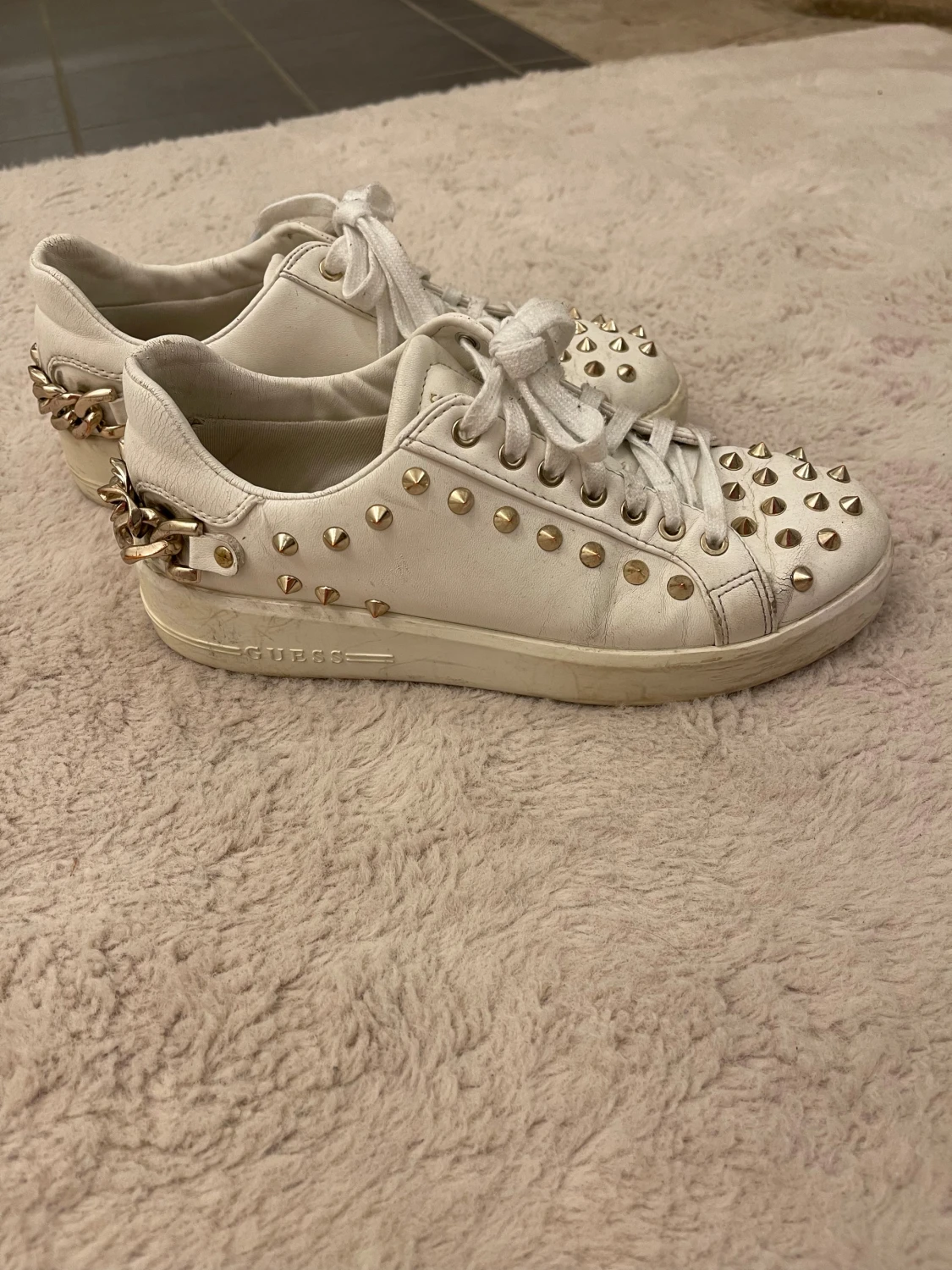 Vita sneakers med nitar från Guess
