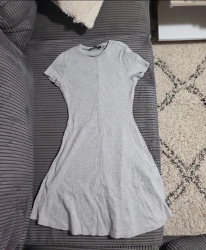 Grå tight klänning (summer dress , party dress) - Tight grå klänning från NYKER, köpte den men använde aldrig den så helt "ny". Den passar bra och är knä längd. M men passar som både M och S. en figurnära passform upptill som blir lite utsvängd nertill. Oanvänt.