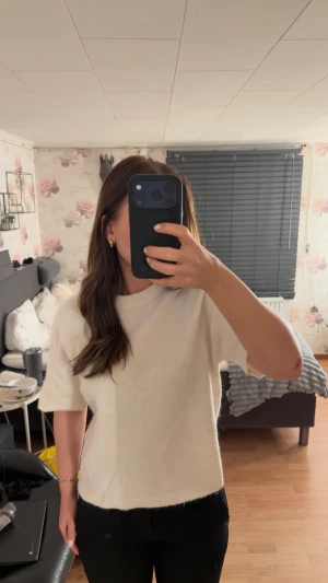 Vit stickad topp med kort ärm - Säljer en enkel och stilren vit stickad topp med rund hals och korta ärmar. Mjuk och skön kvalitet som passar perfekt till jeans eller kjol. Modellen är rak och har en klassisk look som är lätt att matcha med olika outfits.