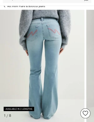 Bootcut ljusblå jeans med broderi - Ljusblå bootcut jeans med rosa broderade detaljer på bakfickorna. 