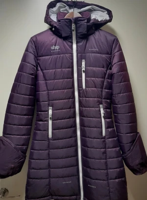 Längre rid jacka -Uhip - HELT NY med tags kvar - Rid dunjacka från Uhip. Ny med fortfarande taggarna kvar. Storlek 160, men är mer som dam Small. Bara varit förvarad i garderob. Rök och djurfritt hem. 