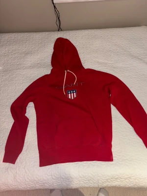 Fin och soft röd GANT hoodie. - Fin Röd Gant hoodie som är i perfekt tillstånd med utan tecken på användning. Perfekt som skol hoodie eller bara chilla i hemma eller på flygplanet.  Nypris 750 kronor. Storlek L men passar även bra på M.