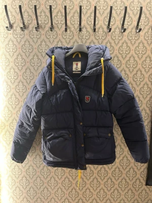 Fjällräven Expedition jacka - Riktigt snygg dunjacka från Fjällräven i storlek S. Den är i väldigt bra skick med endast små defekter som väldigt lätt går att laga(syns på sista bilden) Jackan är perfket för kalla dagar🙌🏻🙌🏻