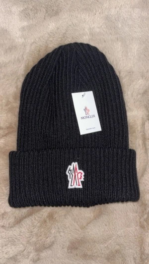 Moncler mössa - Säljer en moncler mössa perfekt för kalla dagar och vinter, perfekt för dig som gillar märken och mode. Kom dm för eventuella frågor🧐pris kan diskuteras 💯.