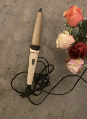 Remington PROluxe locktång - Säljer en Remington PROluxe locktång i beige och guld med digital display. Tången har en konformad form och svart sladd, perfekt för att skapa snygga lockar och waves. Ergonomisk design och enkel att använda för att få till drömhåret.Använd fåtal gånger. Någon enstaka repa, inga andra problem.