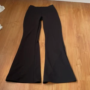 Svarta bootcut byxor - Snygga svarta bootcut byxor med hög midja. Perfekta för en stilren look. Materialet är mjukt och stretchigt vilket ger en bekväm passform.
