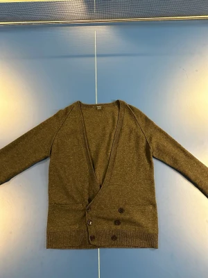 Filippa K cardigan  - En riktigt mysig Filippa K cardigan i storlek Small samt färg mörkgrå (ser brun ut pga ljuset). Skick 8/10 väldigt sparsamt använd, lite nopprig och ett av knapp hålen är lite extra öppet. Kom dm för fler frågor osv!