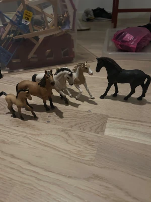 5 Schleich hästar - Säljer en beige ridväst med svarta detaljer från Hööks. Västen har en klassisk, figurnära passform och är tillverkad i slitstark polyester. Perfekt för dig som gillar hästar och vill ha en snygg look i stallet. Västen har dragkedja framtill och diskret logga på bröstet.
