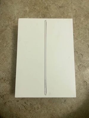 iPad Air 2 Wi-Fi + Cellular 64GB Silver - Apple iPad Air 2 med Wi-Fi och Cellular, 64GB lagring i silver. Komplett med originalkartong. Några synliga repor och slitage på baksidan, men i övrigt gott skick. Perfekt för surf, appar och underhållning.
