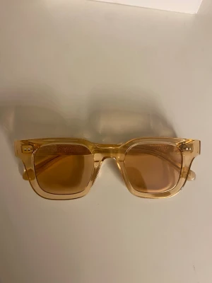 solglasögon från CHIMI - Snygga solglasögon från CHIMI i guldig färg med klassisk rektangulär form. Kommer med originalförpackning, vit förvaringspåse och putsduk. Perfekta för att lyfta din stil med en modern touch. I modellen 04