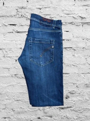 Dondup slim fit-jeans  - Exklusiva slim fit-jeans från italienska premium­märket Dondup. Klassisk blå tvätt med stilrena detaljer och modern passform. Använda men i mycket bra skick. Midja: 41 cm Längd: 86 cm Inga hål eller större skador. Hör av dig vid frågor 👖✨