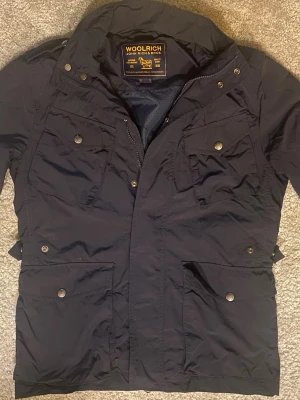 Woolrich field jacket - En riktig fet mörkblå jacka från Woolrich som är perfekt nu till våren! jackan är sjukt eftertraktad och är slutsåld överallt.. storlek: xs kan passa s                                                            Hör av er vid minsta fundering 💭