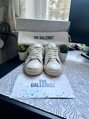 The Gallerist - Ett par svin snygga vita skor från The Gallerist med svarta svarta detaljer på hälen och sidorna. Nypris är 2699kr. Det är väldigt fint skick på skorna, dem har inga hål eller liknande.Modellen heter Geneva. Allt medföljer. Skorna är i storlek 39! Jag skickar samma dag! Hör av er!🙌